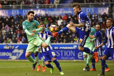 Barcelona’s Lionel Messi, left, duels for the ball with Alaves’s Aleksandar Katal. Alvaro Barrientos / AP Photo