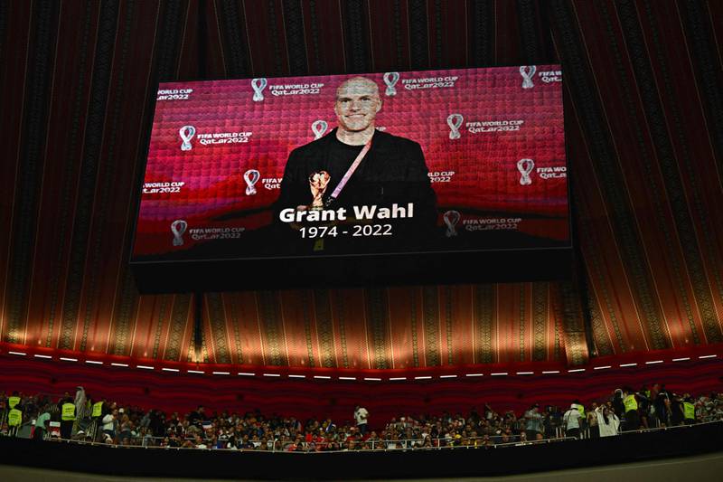 A giant screen displays a photo of US journalist Grant Wahl who died after he collapsed in the stadium's press area while covering the match between Argentina and Netherlands during the Qatar 2022 World Cup quarter-final football match between England and France at the Al-Bayt Stadium in Al Khor, north of Doha, on December 10, 2022.  (Photo by Anne-Christine POUJOULAT  /  AFP)