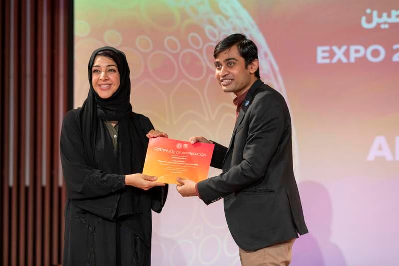 Reem Al Hashimy, UAE Minister of State for International Co-operation and Director General of Expo 2020 Dubai, presents an award to Abhishek Rajput, who has visited the world's fair 63 times so far. Photo: Expo 2020 Dubai