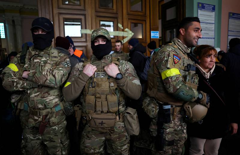 Ben Grant, right, and other foreign fighters from the UK at the main train station in Lviv, Ukraine. Reuters