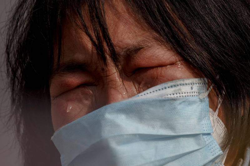 A mother reacts as she pleads with police to allow her daughter to pass a checkpoint for cancer treatment after she arrived from Hubei province at the Jiujiang Yangtze River Bridge in Jiujiang, Jiangxi province, China, as the country is hit by an outbreak of a new coronavirus. Reuters