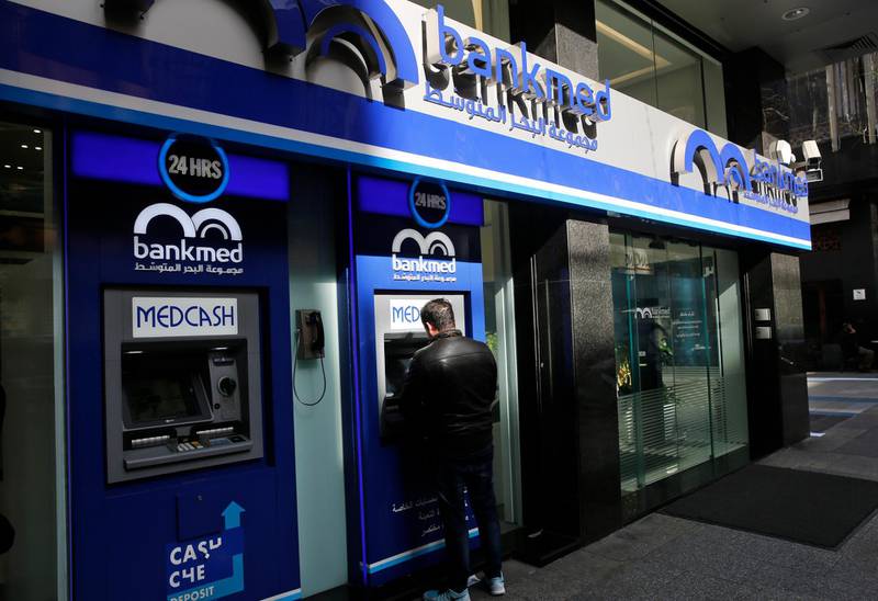 A man uses the ATM outside a bank, in Beirut, Lebanon, Tuesday, Jan. 22, 2019. Lebanon's finance minister says a report by Moody's Investors Service that downgraded the country's long-term investment ratings reflect the need for quickly forming a new government and implement financial reform. Ali Hassan Khalil's tweet on Tuesday came hours after Moody's downgraded the Lebanon's issuer ratings to Caa1 from B3. (AP Photo/Hussein Malla)