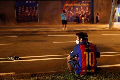 A Barcelona fan sitting on the sidewalk during a protest outside the Camp Nou. Reuters