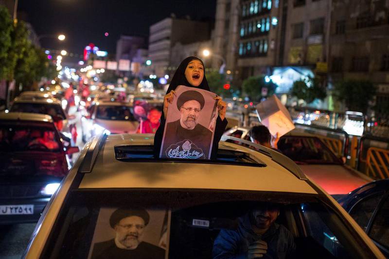 A girl holds a poster of Mr Raisi during a campaign rally in Tehran in 2017.
