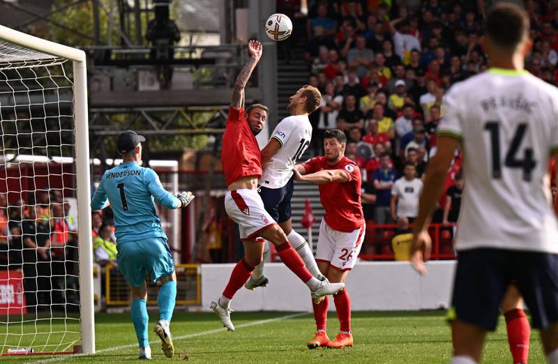 Nottingham Forest defender Steve Cook handles the ball under pressure from Tottenham striker Harry Kane, giving away a penalty and earning a yellow card in the process. AFP