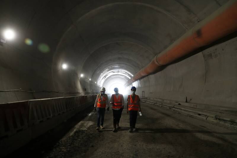 Workers walk into the tunnel.