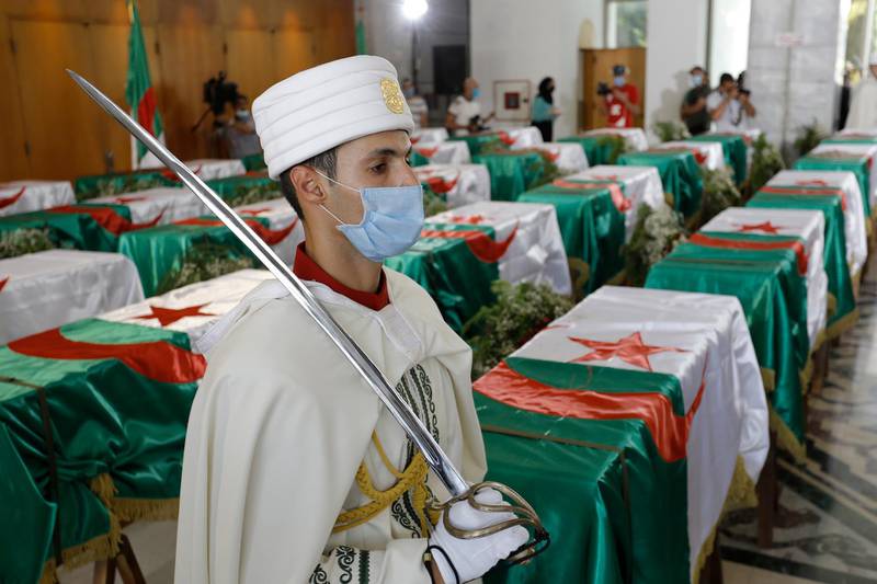 FILE - In this July 3, 2020 file photo, a soldier guards the remains of 24 Algerians at the Moufdi-Zakaria culture palace in Algiers, Friday, July, 3, 2020. After decades in a French museum, the skulls of 24 Algerians decapitated for resisting French colonial forces were formally repatriated to Algeria. French President Emmanuel Macron wants to take further steps to reckon with France's colonial-era wrongs in Algeria but is not considering an official apology, his office said.(AP Photo/Toufik Doudou, File)