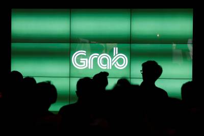 FILE PHOTO - People wait for the start of ride-hailing company Grab's fifth anniversary news conference in Singapore June 6, 2017. REUTERS/Edgar Su/File Photo