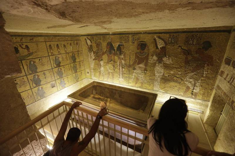 A file photo of tourists looking at the tomb of King Tut as it is displayed in a glass case at the Valley of the Kings in Luxor. Egypt's antiquities minister Mamdouh El Damaty, said on March 17, 2016, that analysis of scans of the famed king's burial chamber has revealed two hidden rooms that could contain metal or organic material. Amr Nabil/AP Photo