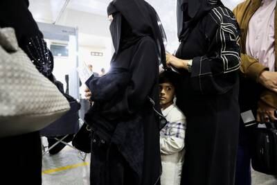 A boy stands with relatives in a line at the departures lounge to board the flight at Sanaa International Airport. Reuters