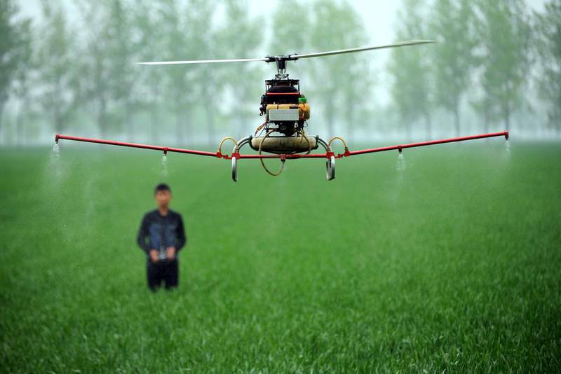 On a farm in Bozhou, central China, a man controls a drone to spray pesticides. China's economy expanded 7.4 per cent year-on-year in the first three months of the year, marking a further slowing in the world's second-largest economy. (AFP / April 15, 2014)