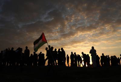 epaselect epa06392120 Palestinian protesters wave a Palestinian flag during clashes near the border with Israel, against US President decision to recognize Jerusalem as the capital of Israel, in the east of Gaza City, 15 December 2017. Two Palestinians were killed during the clashes in the east of Gaza Strip. US president Donald J. Trump on 06 December announced he is recognizing Jerusalem as the Israel capital and will relocate the US embassy from Tel Aviv to Jerusalem.  EPA/MOHAMMED SABER