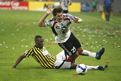 The Al Jazira forward Rafael Sobis is tripped by an Al Ittihad defender.