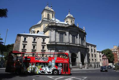 MADRID, SPAIN - JULY 07:  Tourists ride a sightseeing bus past the Basilica de San Francisco el Grande on July 7, 2012 in Madrid, Spain. Despite having the fourth largest economy in the Eurozone, the economic situation in Spain remains troubled with their unemployment rate the highest of any Eurozone country. Spain is currently administering billions of euros of spending cuts and tax increases in a bid to manage its national debt. Spain also has access to loans of up to 100 billion euros from the European Financial Stability Facility which will be used to rescue the country's banks that have been badly affected by a crash in property prices.  (Photo by Oli Scarff/Getty Images)