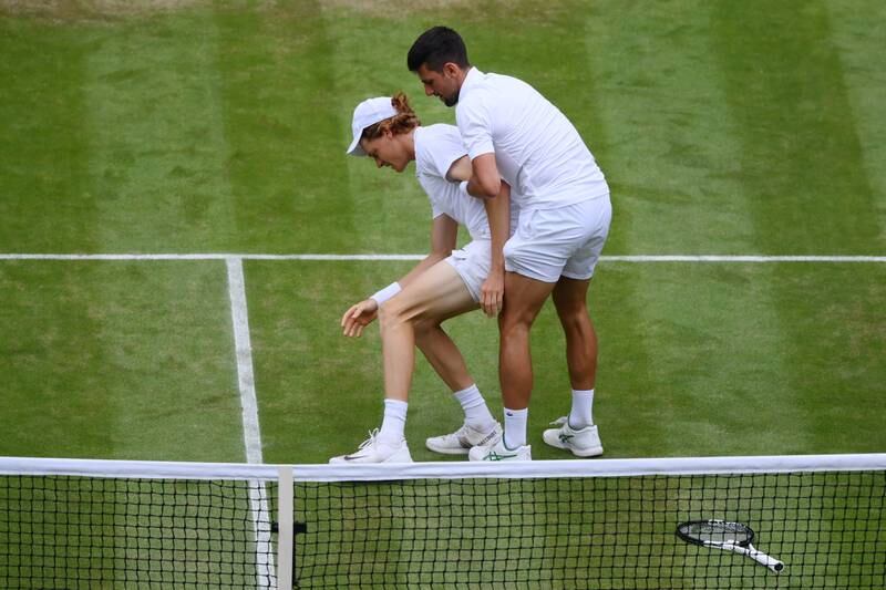 Novak Djokovic helps Jannik Sinner to his feet. Getty 