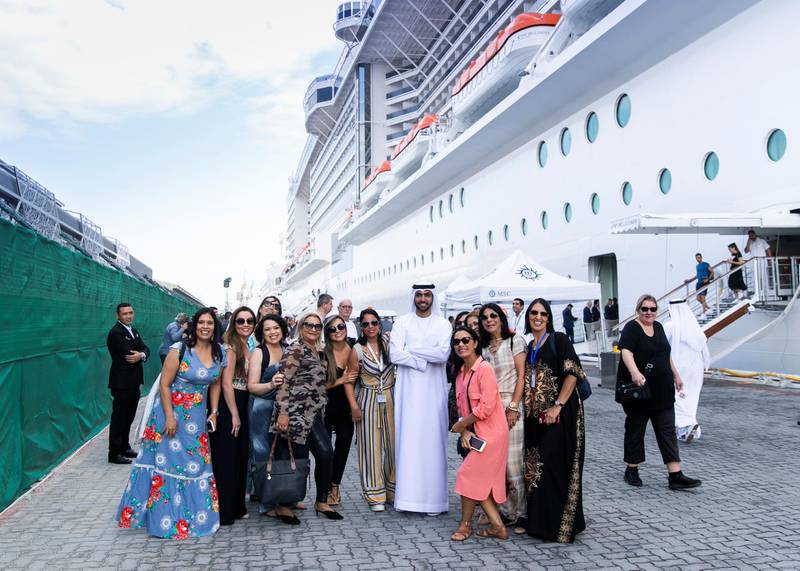 ABU DHABI, UNITED ARAB EMIRATES. 8 DECEMBER 2019. Tourists take a photo with an Emirati man outside MSC Bellissima which arrived today at Abu Dhabi Cruise Terminal.(Photo: Reem Mohammed/The National)Reporter:Section: