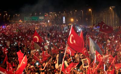 Crowd cheer as Turkey's President Recep Tayyip Erdogan speaks at the July 15 Martyr's bridge on a "National Unity March" to commemorate the one year anniversary of the July 15, 2016 botched coup attempt, in Istanbul, Saturday, July 15, 2017. Turkey commemorates the first anniversary of the July 15 failed military attempt to overthrow president Erdogan, with a series of events honoring some 250 people, who were killed across Turkey while trying to oppose coup-plotters. (AP Photo/Lefteris Pitarakis)
