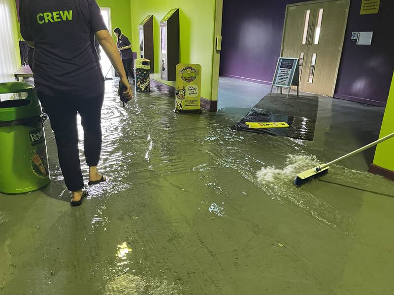 Members of staff at The Milky Way in Devon, clearing out floodwater inside the premises, as heavy rain and flooding hit areas in Cornwall and Devon. PA