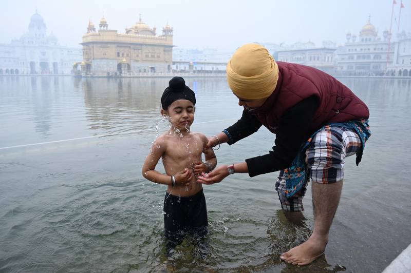 A young Sikh devotee takes a bath in the holy Sarovar (pool) to mark the birth anniversary of the 10th Guru of the Sikhs Guru Gobind Singh at the Golden Temple in Amritsar. AFP