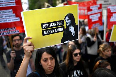 An activist outside the Iranian embassy in Buenos Aires, Argentina, with a sign that reads 'Justice for Mahsa Amini'. AFP