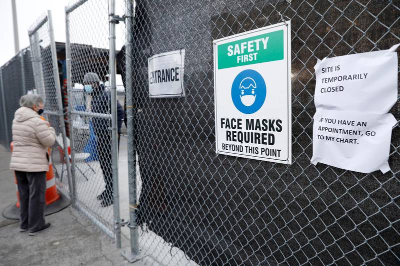 A woman talks to a worker behind a locked gate at the 24-hour coronavirus mass vaccination site at the Brooklyn Army Terminal in Brooklyn, New York. Reuters