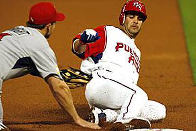 Ramon Vazquez of Team Puerto Rico slides safely into third base, beating a tag by Team USA's third baseman David Wright in the first inning.