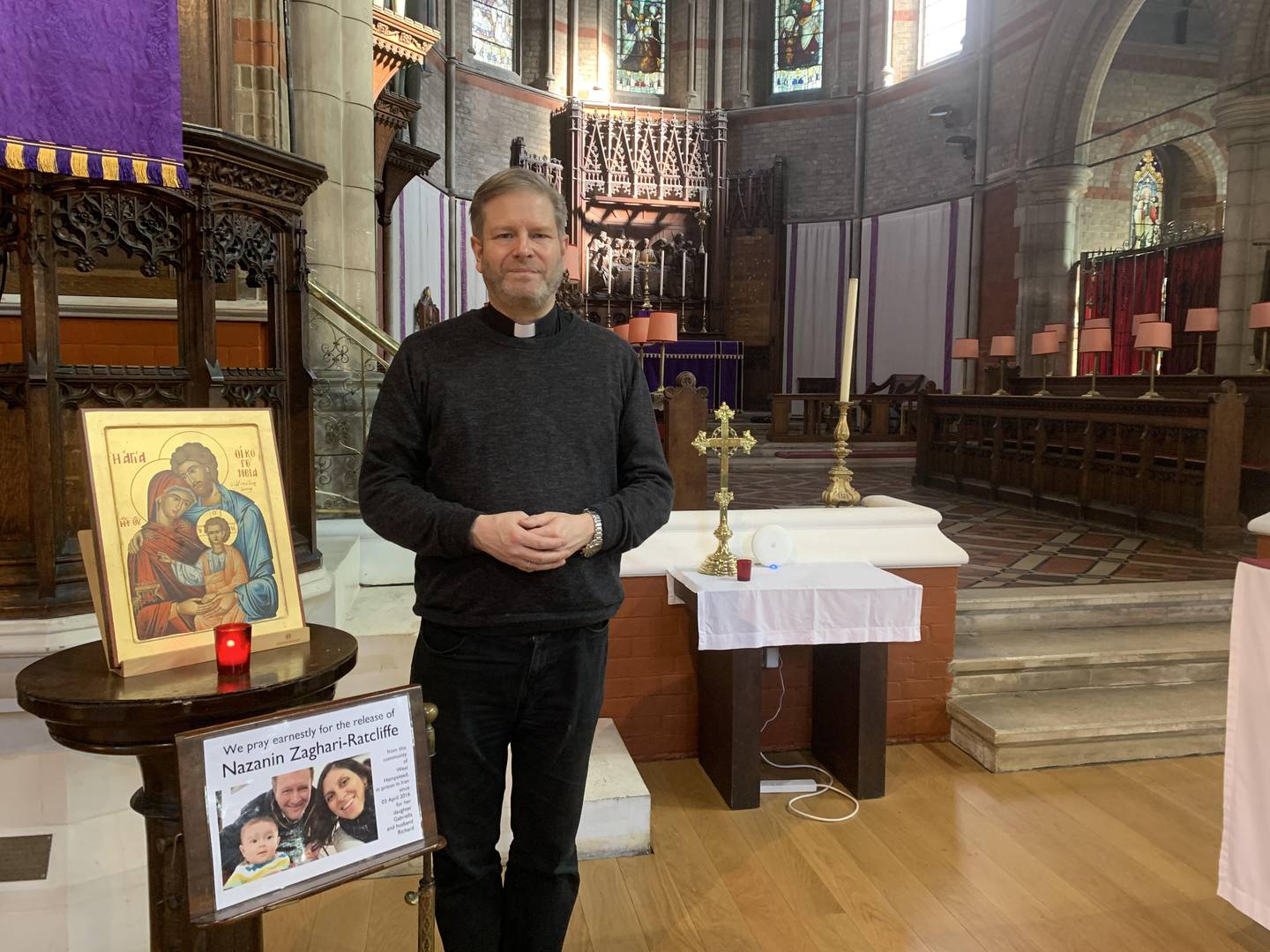 Jonathan Kester beside a photo of the Zaghari-Ratcliffe family. He and his congregation had been praying for them for six years. Laura O'Callaghan / The National