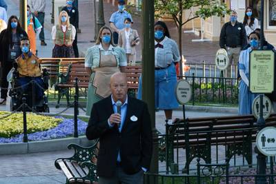 Workers wearing protective masks stand behind Bob Chapek, chief executive officer of Walt Disney Co., as he speak during the reopening of the Disneyland theme park in Anaheim, California, U.S., on Friday, April 29, 2021. Walt Disney Co.'s original Disneyland resort in California is sold out for weekends through May, an indication of pent-up demand for leisure activities as the pandemic eases in the nation's most-populous state. Photographer: Bing Guan/Bloomberg