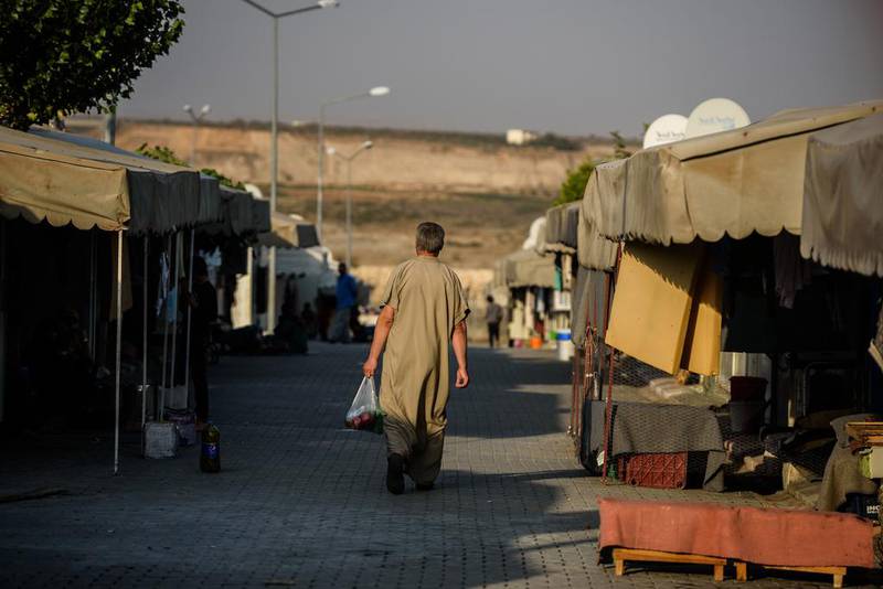 A Syrian man walks at a refugee camp in the Kilis district of Gaziantep, southeastern Turkey. Economists have long debated whether giving humanitarian aid in cash or in kind is better at encouraging long-term development Ozan Kose / AFP Photo