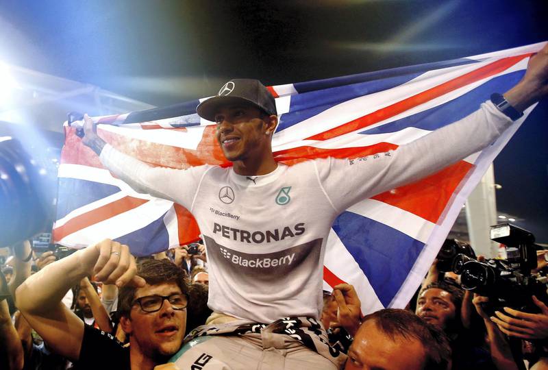 ABU DHABI, UNITED ARAB EMIRATES - NOVEMBER 23:   (EDITORS NOTE: Retransmission of #459457336) Lewis Hamilton of Great Britain and Mercedes GP celebrates with his team after winning the World Championship after the Abu Dhabi Formula One Grand Prix at Yas Marina Circuit on November 23, 2014 in Abu Dhabi, United Arab Emirates.  (Photo by Clive Rose/Getty Images)