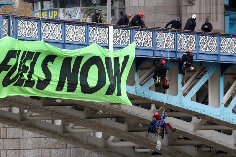 Police officers try to remove Extinction Rebellion activists from Tower Bridge, who hung a banner off the London landmark on Friday morning. Reuters