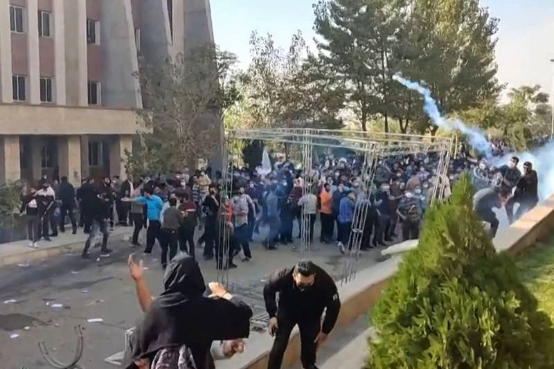 Protesters attempt to dodge projectiles fired at them during clashes at Iran's Islamic Azad University in Tehran. AFP
