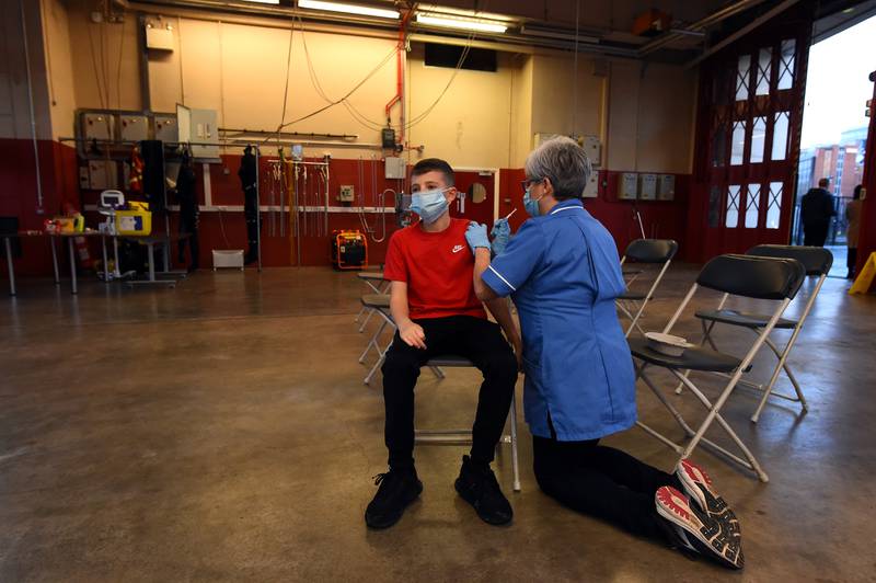 Nurse Ann Craven inoculates Jordan Ward, 12, with his first shot of the Pfizer vaccine at a pop-up vaccination clinic in the Central Fire Station in Belfast, Northern Ireland. Reuters