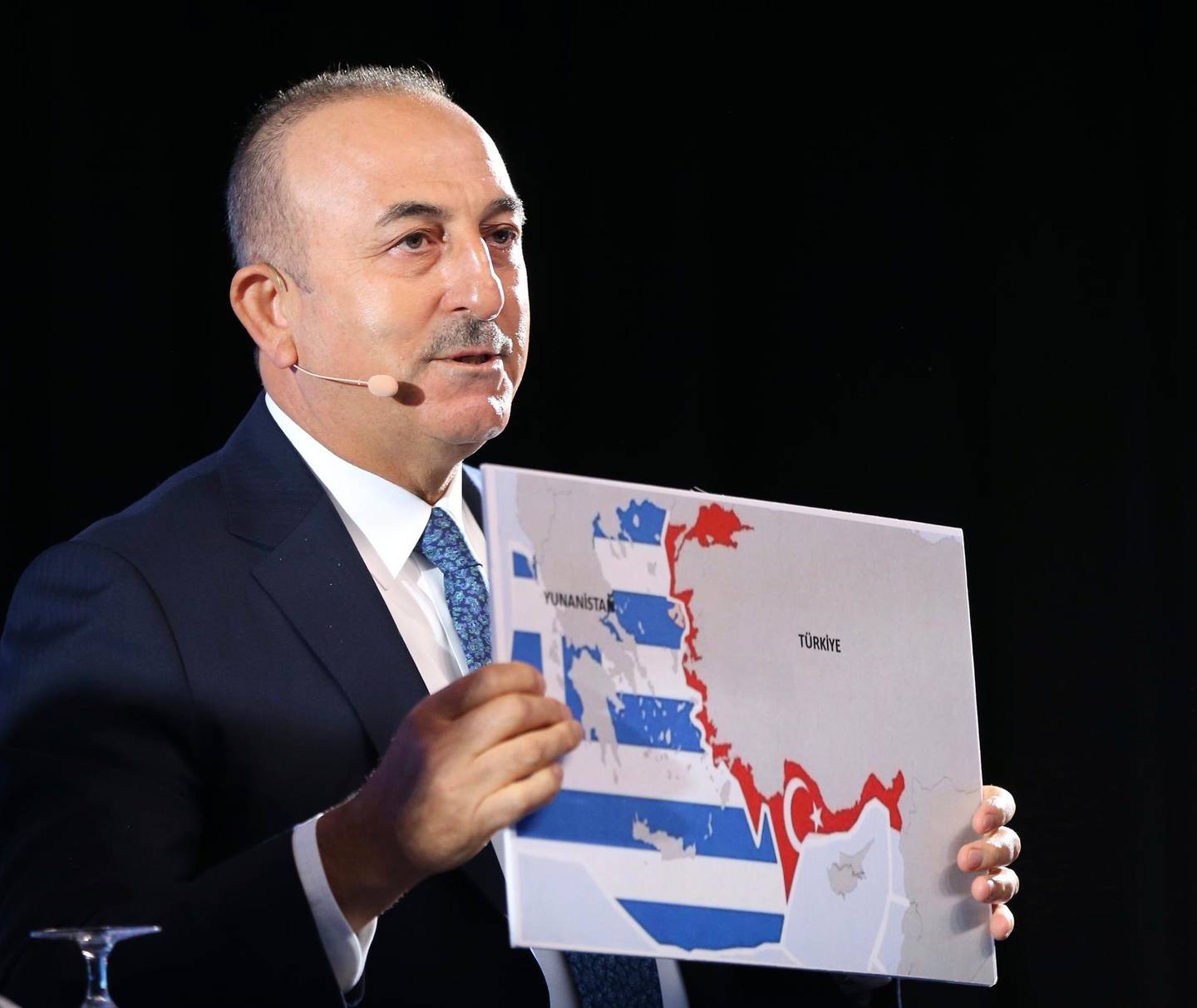 Turkey's Foreign Minister Mevlut Cavusoglu, shows a map of Greece and Turkey as he speaks during a conference in Bratislava, Slovakia, Thursday, Oct. 8, 2020. Cavusoglou met with Greek Foreign Minister Nikos Dendias on the sidelines of the conference and Greek and Turkish officials say the ministers agreed to set a date for the start of a new round of exploratory talks between the two. A dispute between the two NATO allies and longtime rivals over maritime boundaries in the eastern Mediterranean this summer led to fears of open conflict as warships from both sides faced off. (Fatih Aktas/Turkish Foreign Ministry via AP, Pool)