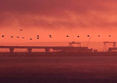 Birds fly past a road-and-rail bridge, which is constructed to connect the Russian mainland with the Crimean peninsula, at sunrise in the Kerch Strait, Crimea November 26, 2018. REUTERS/Pavel Rebrov     TPX IMAGES OF THE DAY