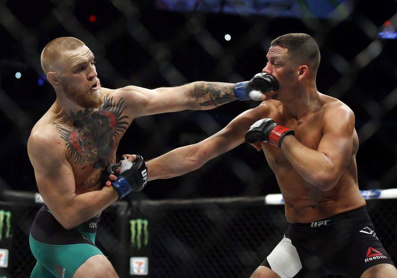 Conor McGregor, left, punches Nate Diaz during their UFC 202 but. AP