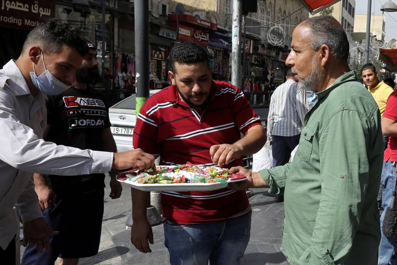 A Jordanian man distributes sweets to passersby on the occasion of the Prophet Mohammad's birthday in downtown Amman, Jordan October 29, 2020. REUTERS/Muhammad Hamed