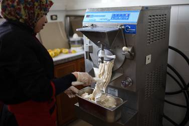 Noora Abu Jomiza, a 32-year-old gelato maker, takes the latest banana-flavoured batch out of the machine in Gelato di Gaza’s production room in the Bureij refugee camp. Rosie Scammell for The National