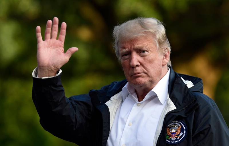 President Donald Trump waves as he walks across the South Lawn of the White House in Washington, Wednesday, Sept. 19, 2018, after returning from a trip to survey the damage from Hurricane Florence in North Carolina and South Carolina. (AP Photo/Susan Walsh)