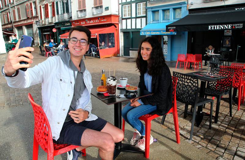 Mathys Marquez takes a selfie as he has breakfast with his cousin Juna Marquez at a cafe in Bayonne, southwestern France. AP Photo