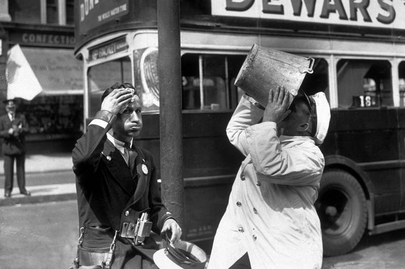 A bus driver and conductor stop for a water break in London in 1935.