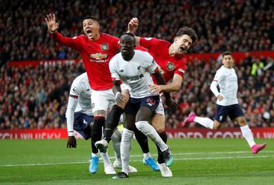 Manchester United's Harry Maguire and Marcos Rojo in action with Liverpool's Sadio Mane. Reuters