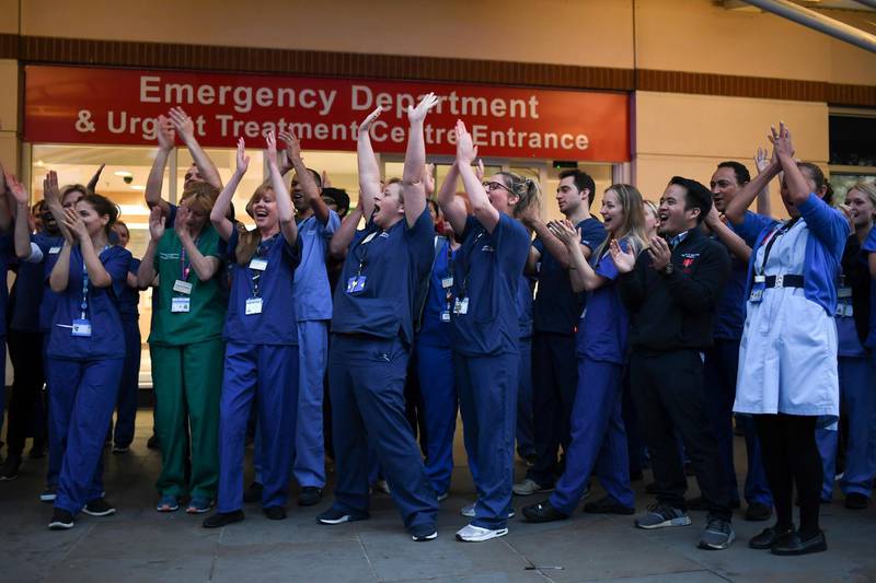NHS staff applaud outside the Chelsea and Westminster Hospital in London during the weekly "Clap for our Carers" in April 2020. The applause took place across Britain every Thursday at 8pm to show appreciation for healthcare workers, emergency services, and all those helping people with coronavirus and keeping the country functioning while most people stayed at home in the lockdown. AP Photo