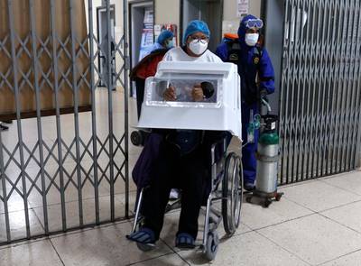 A nurse pushes Covid-19 patient in a wheelchair at Honorio Delgado Hospital in Arequipa, Peru. Due to surge of Delta variant cases, the city is under lockdown. AP Photo