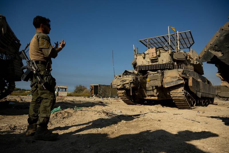 An Israeli soldier directs a tank driver near the northern Gaza border on November 17, 2023 in southern Israel. Getty Images.