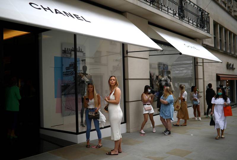 People are seen outside a Chanel store, as shops re-open amid the coronavirus outbreak, in New Bond Street in London, Britain June 15, 2020. REUTERS