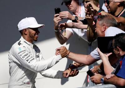 Mercedes driver Lewis Hamilton celebrates with fans after his win. Tony Gutierrez / AP Photo