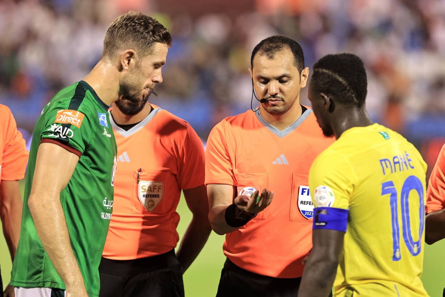 AD DAMMAM, SAUDI ARABIA - AUGUST 14: Jordan Henderson of Al-Ettifaq and Sadio Mane of Al-Nassr take part in the coin toss with match referee Mohammed Al Hoaish prior to the Saudi Pro League match between Al-Ettifaq and Al Nassr at Prince Mohamed bin Fahd Stadium on August 14, 2023 in Ad Dammam, Saudi Arabia. (Photo by Essa Doubisi / Getty Images)