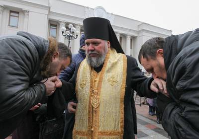 epaselect epa07242232 Ukrainian believers of the Ukrainian Orthodox Church of the Moscow Patriarchate kiss hands of a priest during their praying in front of the parliament building in Kiev, Ukraine, 20 December 2018. Believers protest against changing of name their church. Ukrainian Parliament voted on 20 December the draft law according to which the Ukrainian Orthodox Church of the Moscow Patriarchate should change the name and indicate its affiliation with Russia. Bishop of the Ukrainian Orthodox Church of the Kyiv Patriarchate, Metropolitan of Pereiaslav and Bila Tserkva Epifaniy (Serhiy Dumenko) has been elected head of the local Orthodox Church in Ukraine at the unification council of the Ukrainian Orthodox churches on 15 December 2018. The Holy Synod announced its decision that the Ecumenical Patriarchate would proceed to grant autocephaly to the Church of Ukraine on 11 October 2018.  EPA/STEPAN FRANKO