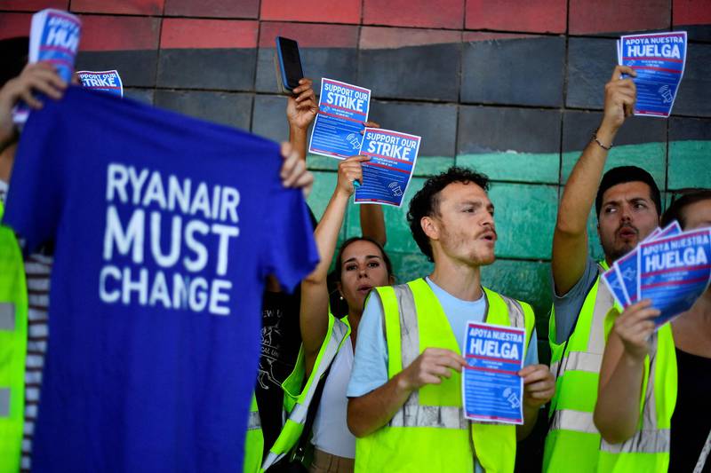 Ryanair employees hold flyers as they protest at El Prat airport. AFP